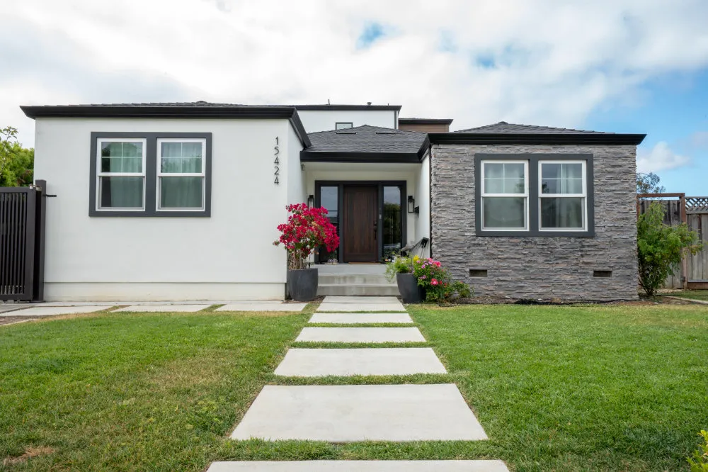 Landscape design project with a modern front yard, concrete walkway, green lawn, and planted entry