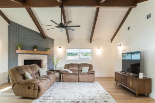 Interior architecture project with exposed ceiling beams, fireplace wall, and open living room layout