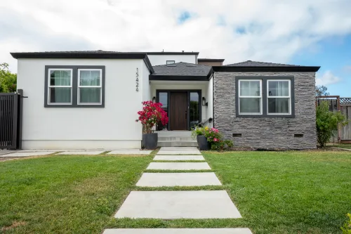 Landscape design project with a modern front yard, concrete walkway, green lawn, and planted entry
