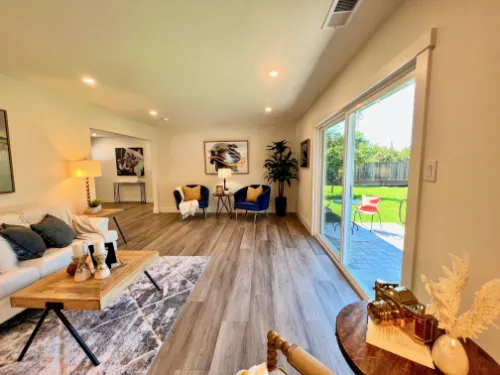 Remodeling project with open living space, updated flooring, large sliding glass doors, and natural light